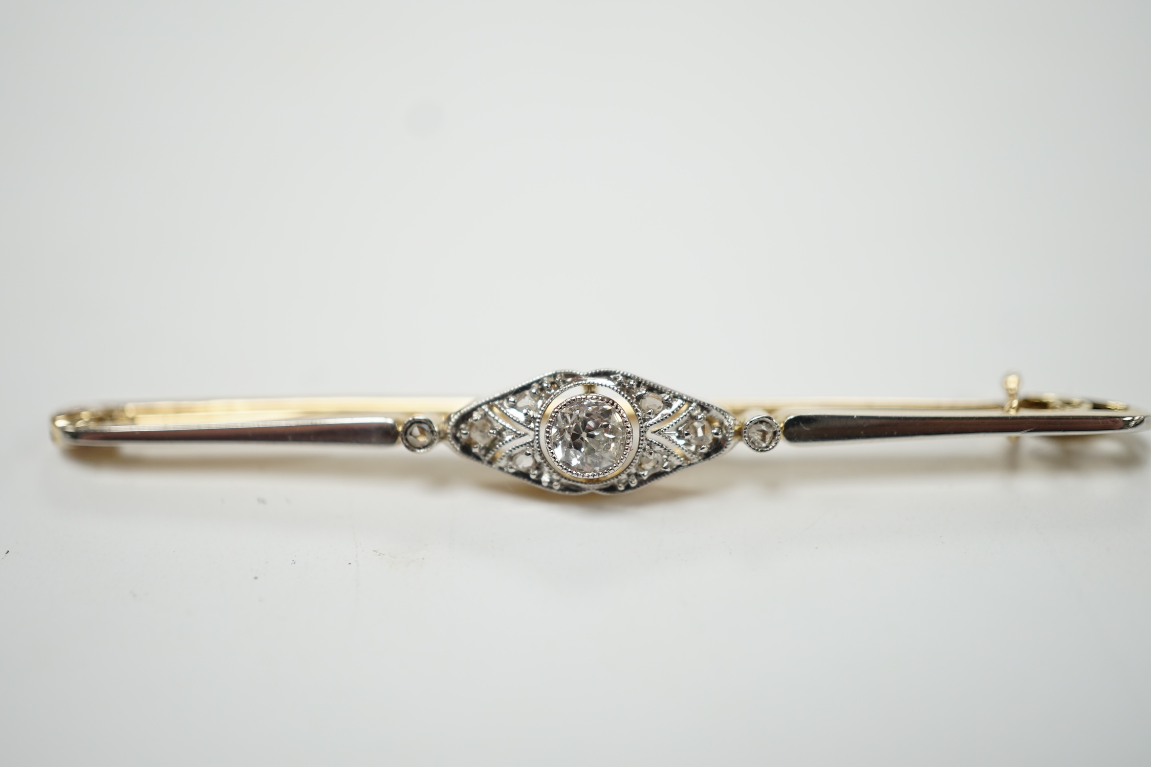 An Edwardian yellow metal and diamond cluster set bar brooch, 55mm, gross weight 3.6 grams. Good condition.